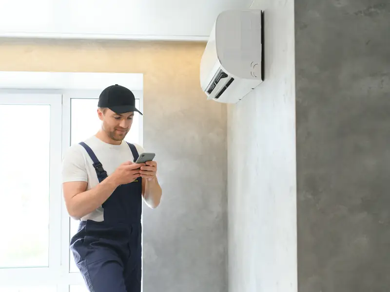 Installateur vérifiant le bon fonctionnement d'une unité après intervention