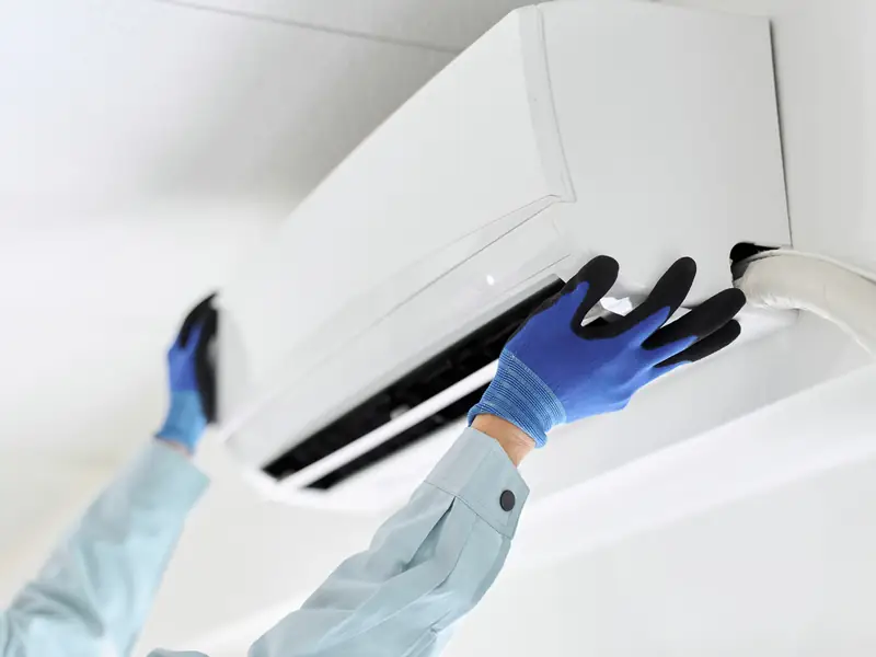 Nettoyage d'une unité murale de climatisation avant l'arrivée des locataires
