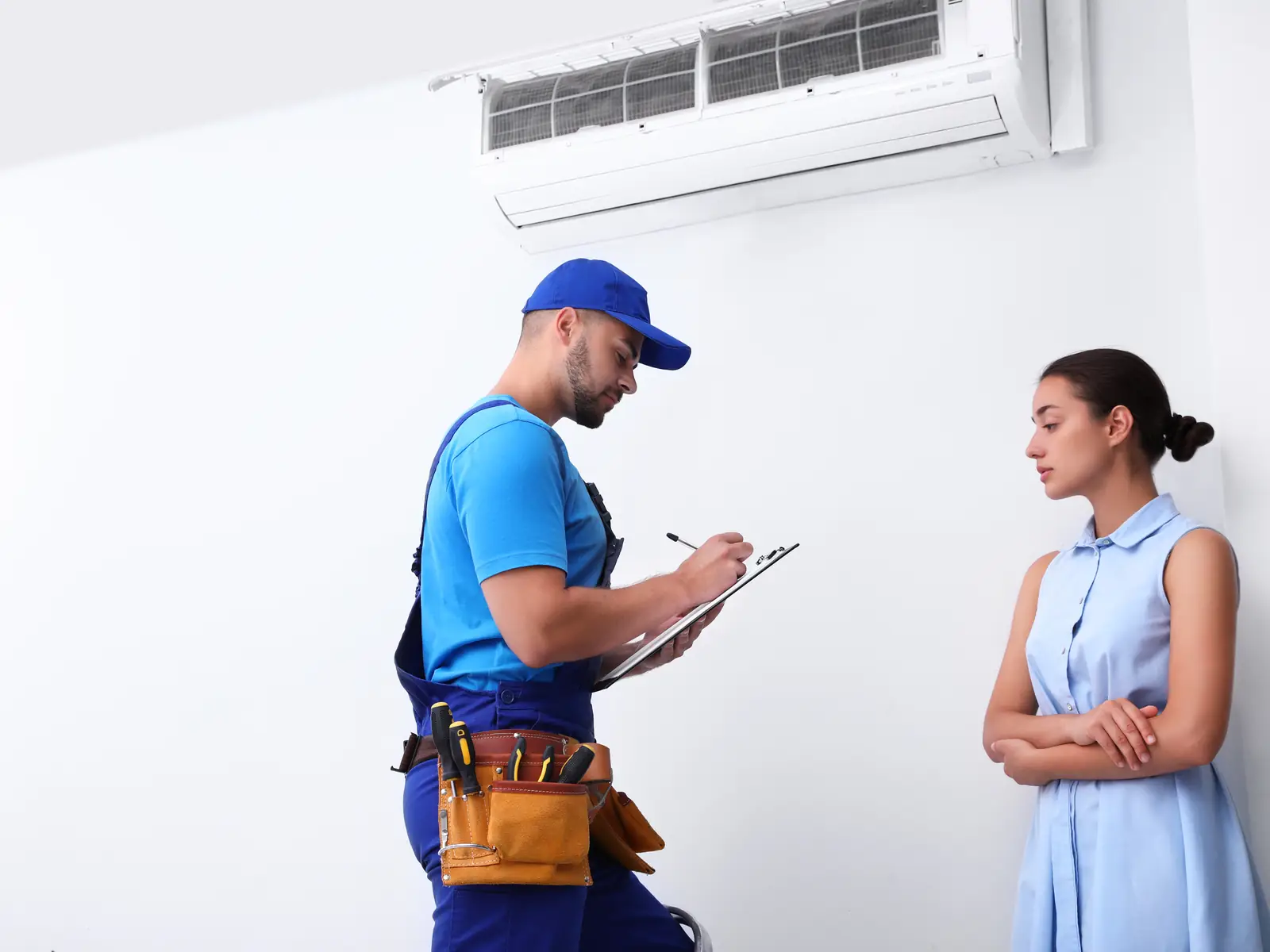 Technicien expliquant à une cliente l'origine du bruit de sa climatisation murale
