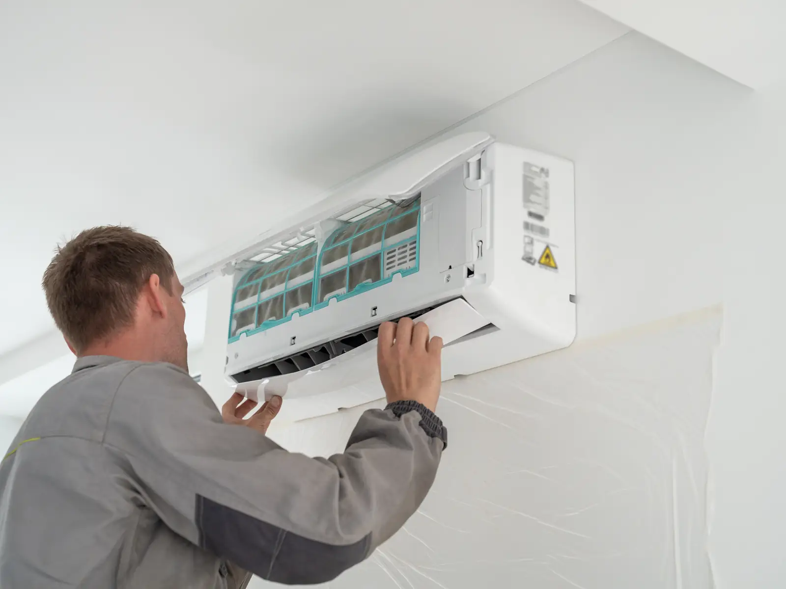 Technicien intervenant sur un split mural, type d'appareil courant dans une petite boutique