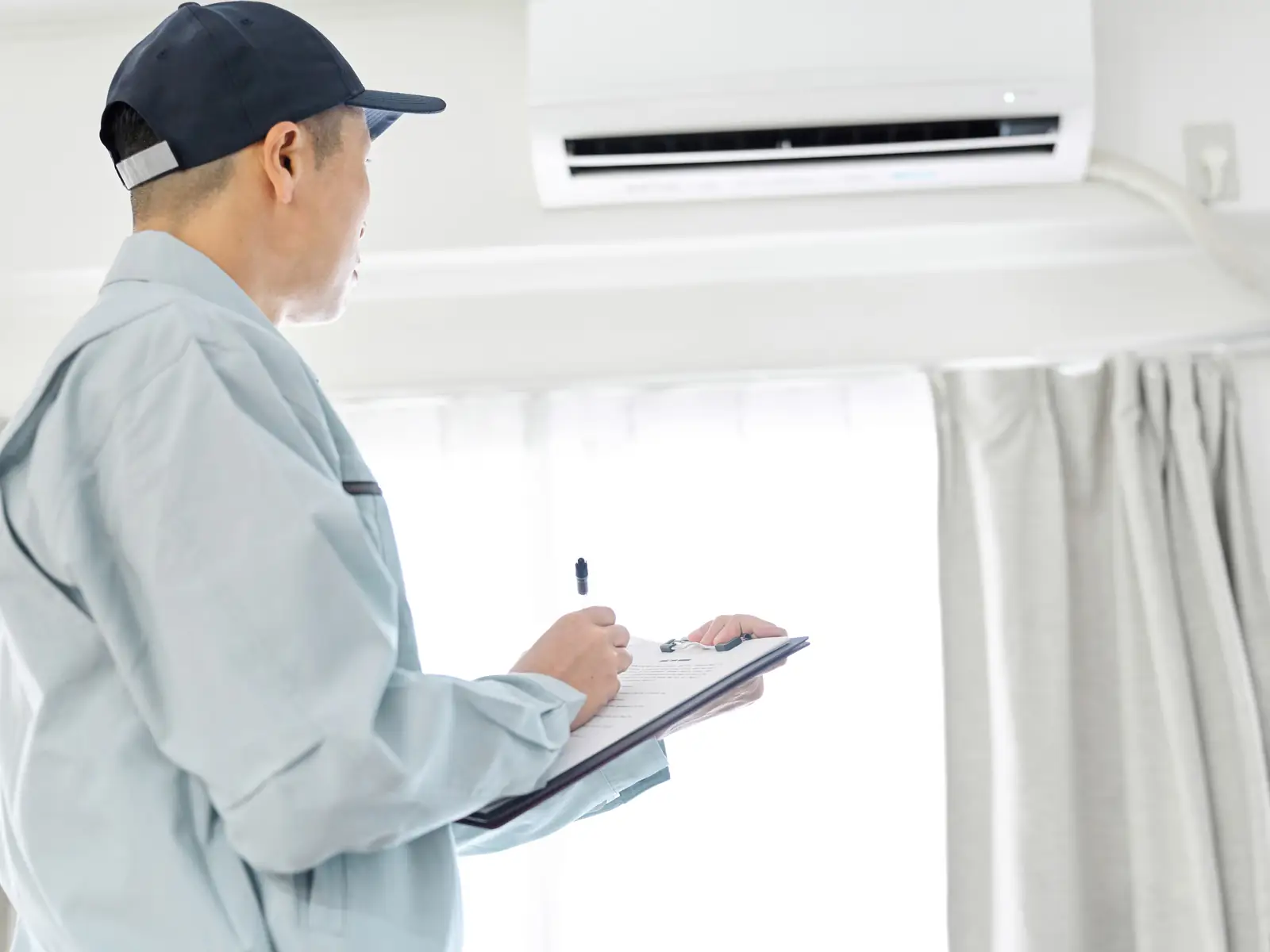 Technicien remplissant le relevé des contrôles après l'entretien d'une climatisation