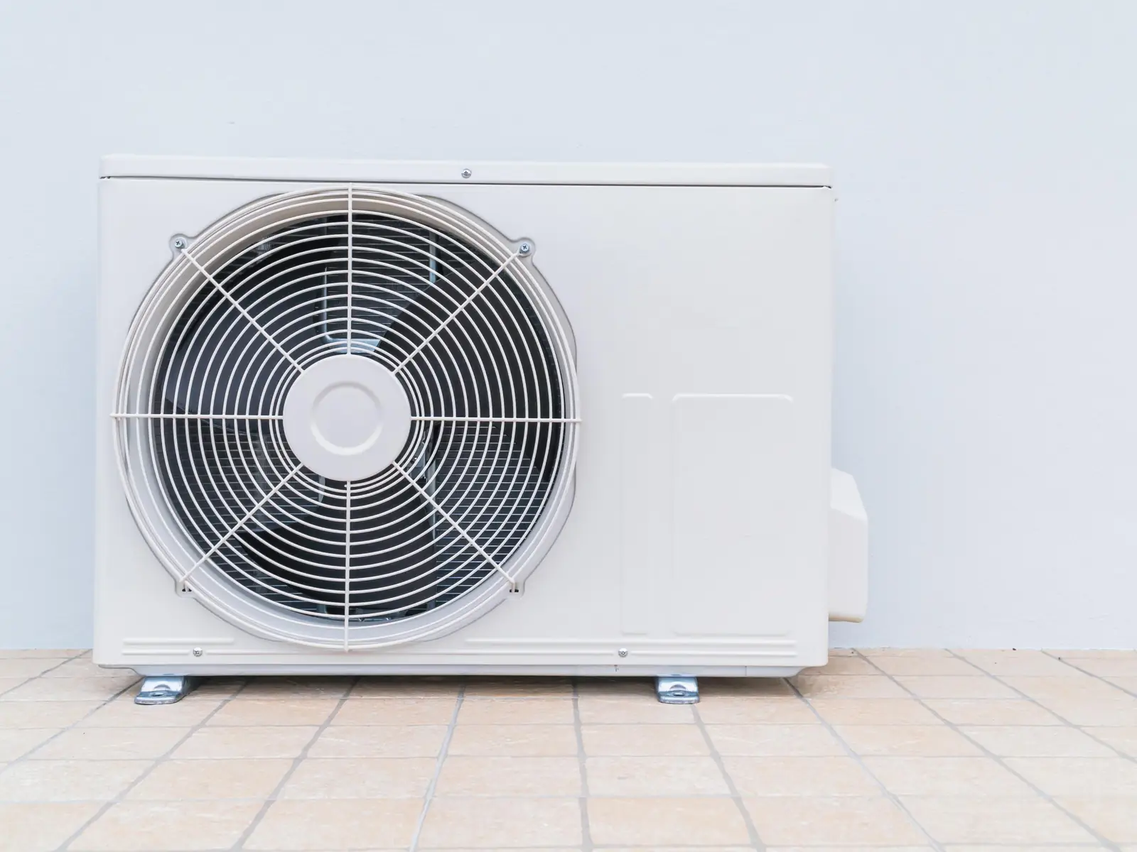Unité extérieure de climatisation posée au sol dans un espace dégagé