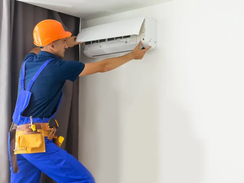 Installateur au travail sur une unité murale à Nice